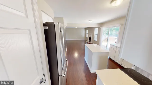 a view of a hallway with wooden floor and closet