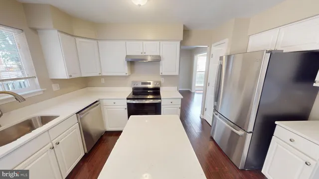a view of a hallway with wooden floor and entryway