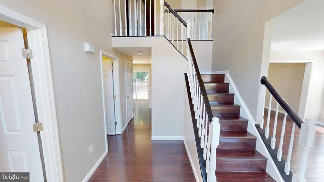 a view of an entryway with wooden floor and staircase
