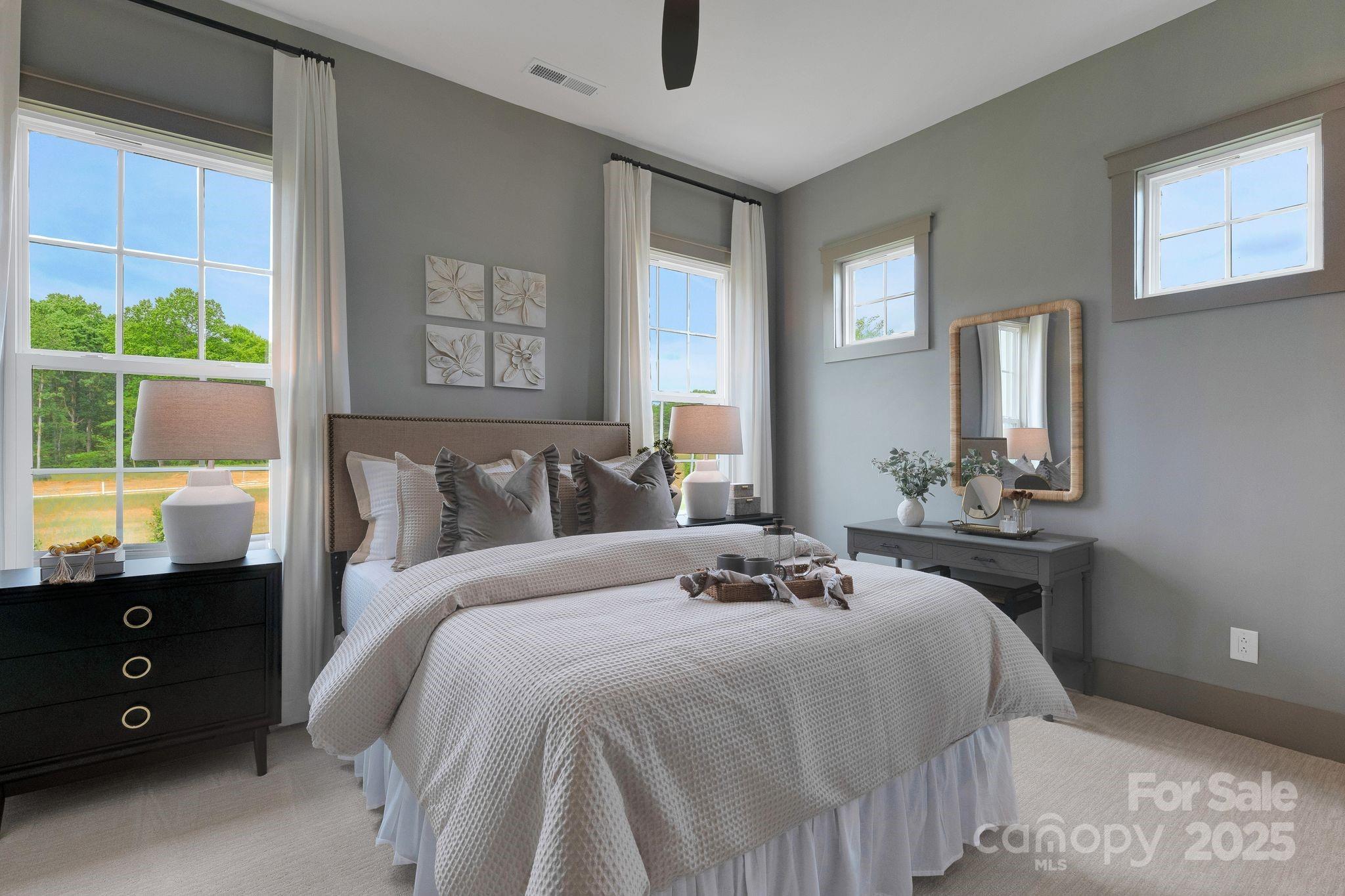 13648 Glennmayes Road Huntersville, NC 28078 - Photo 16 of 32 a bedroom with a bed a dresser a mirror and windows