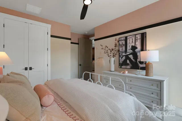 a bedroom with a bed and a lamp on dresser