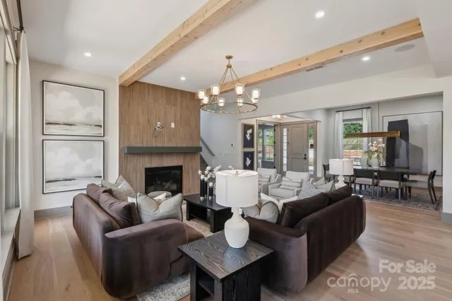 a living room with furniture a chandelier and a fireplace