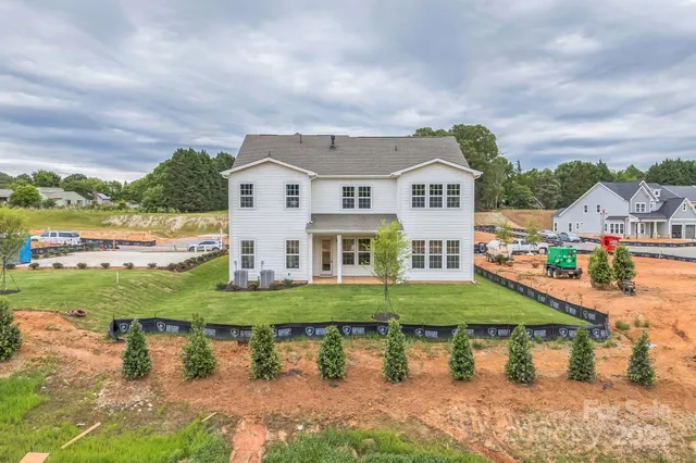 a view of house with a big yard and potted plants