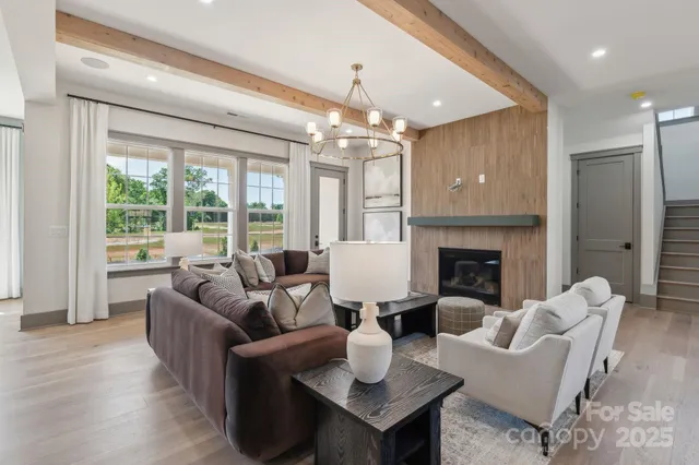 a living room with furniture a fireplace and a chandelier