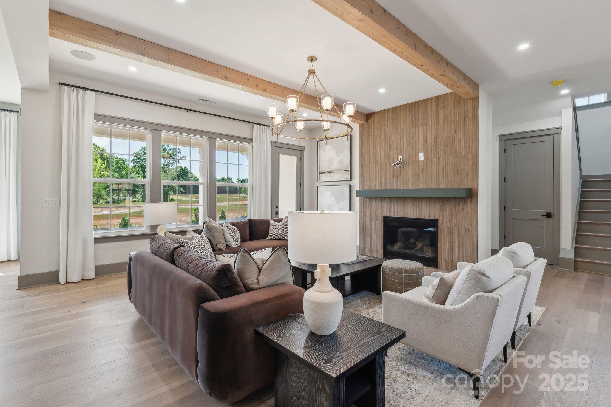 13648 Glennmayes Road Huntersville, NC 28078 - Photo 4 of 32 a living room with furniture a fireplace and a chandelier