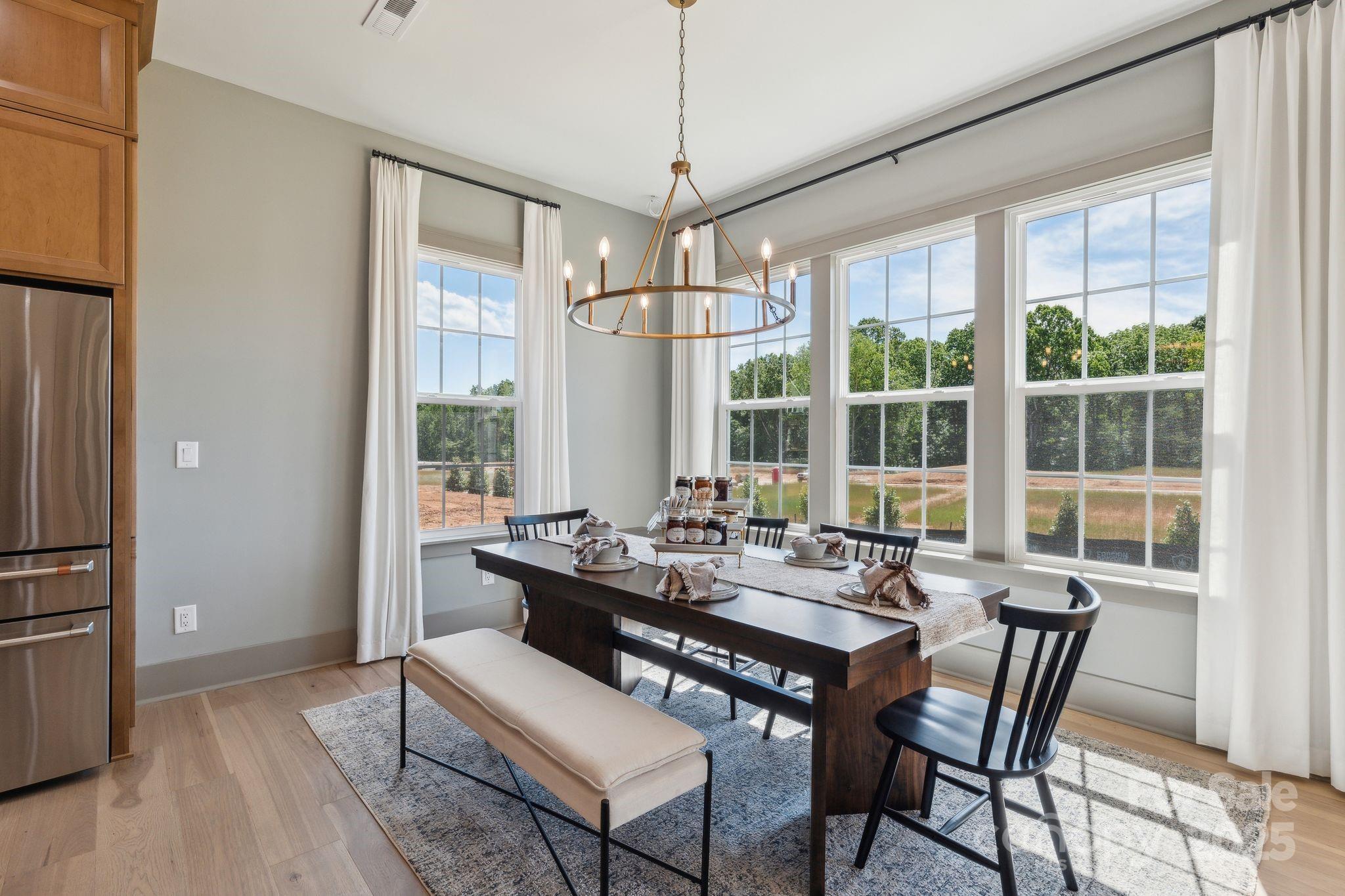 13648 Glennmayes Road Huntersville, NC 28078 - Photo 9 of 32 a dining room with furniture a chandelier and wooden floor