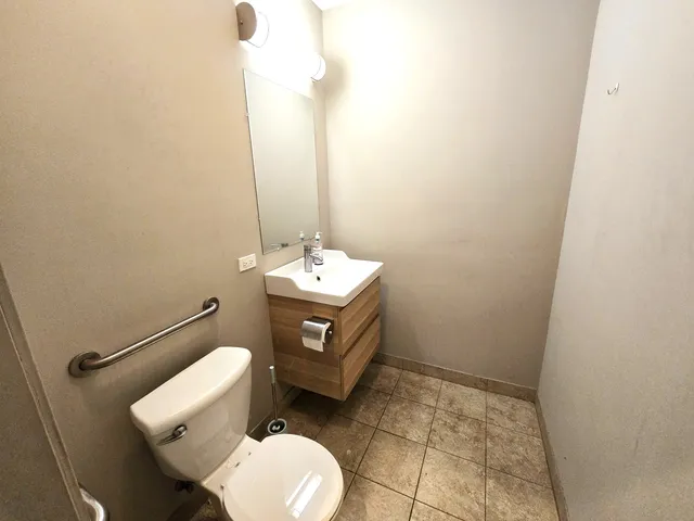 a bathroom with a toilet sink and mirror