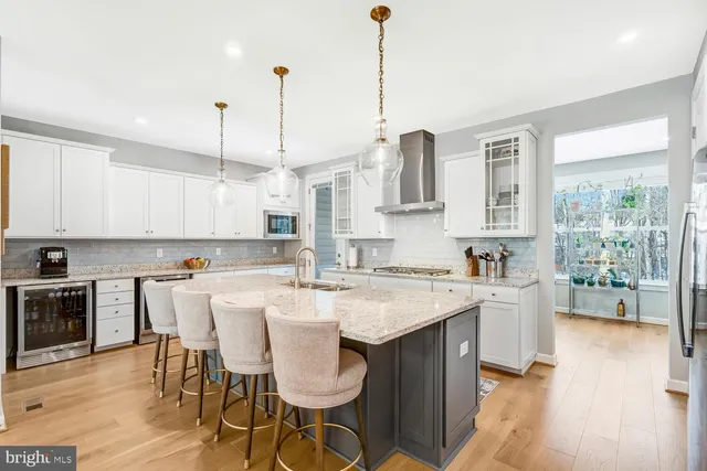 a kitchen with a sink stove and white cabinets with wooden floor