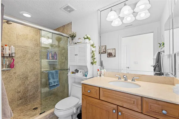 a bathroom with a sink vanity granite toilet and shower