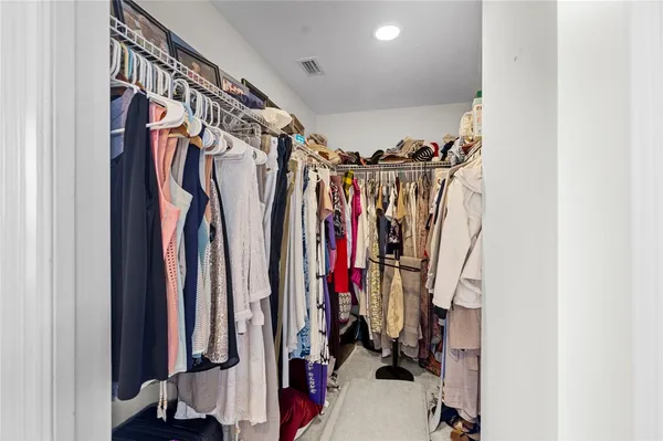 a view of walk in closet with clothes