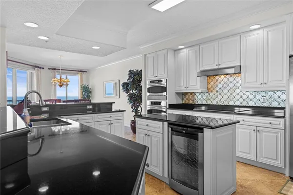 a kitchen with kitchen island granite countertop a sink stove and cabinets