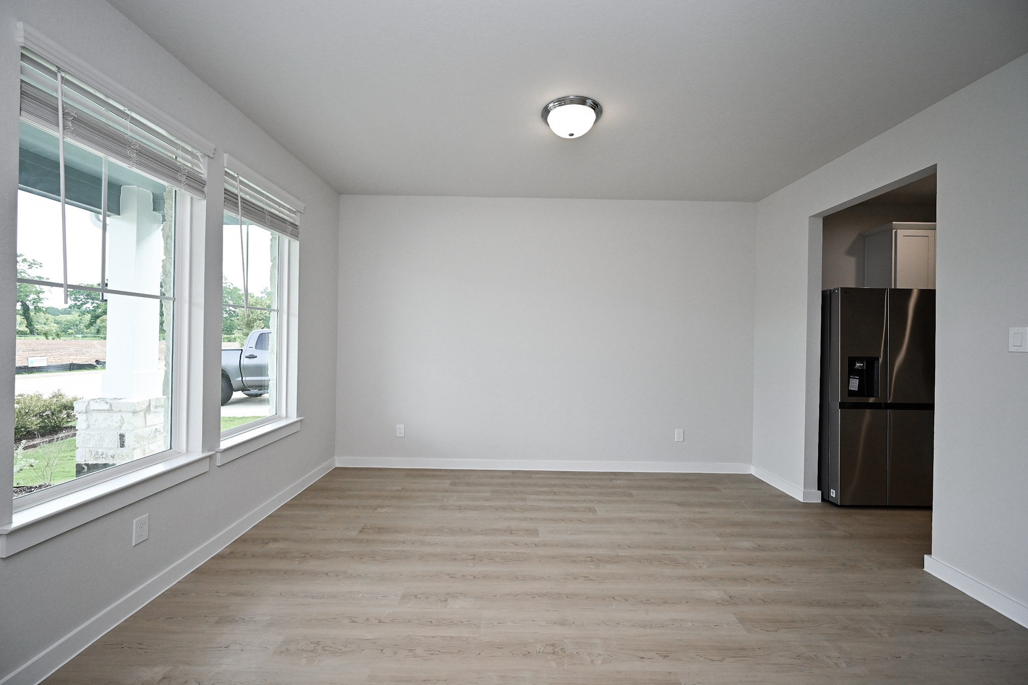 33019 School Hl Road Fulshear, TX 77441 - Photo 5 of 38 a view of an empty room with wooden floor and a window