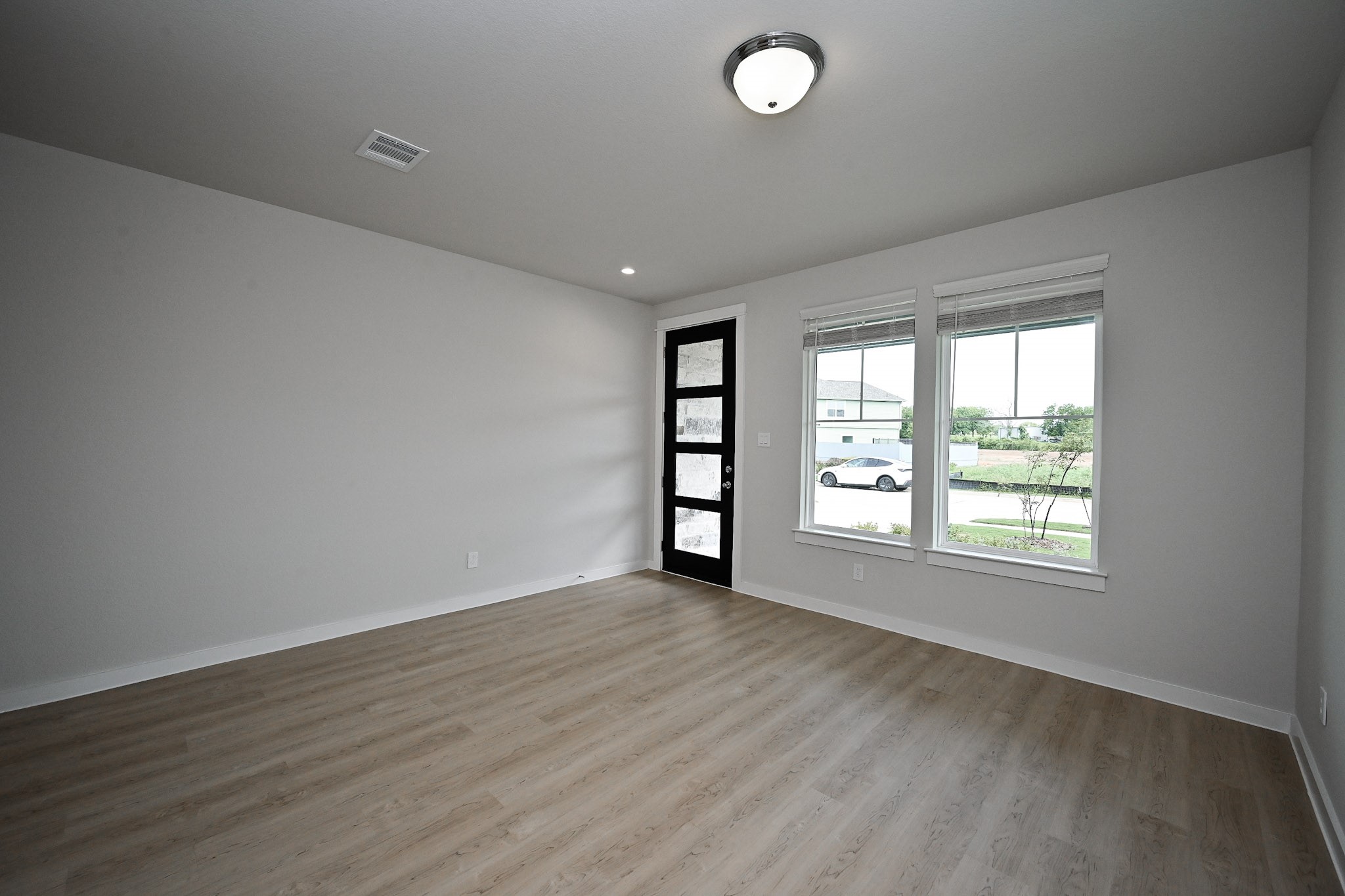33019 School Hl Road Fulshear, TX 77441 - Photo 6 of 38 an empty room with wooden floor and windows