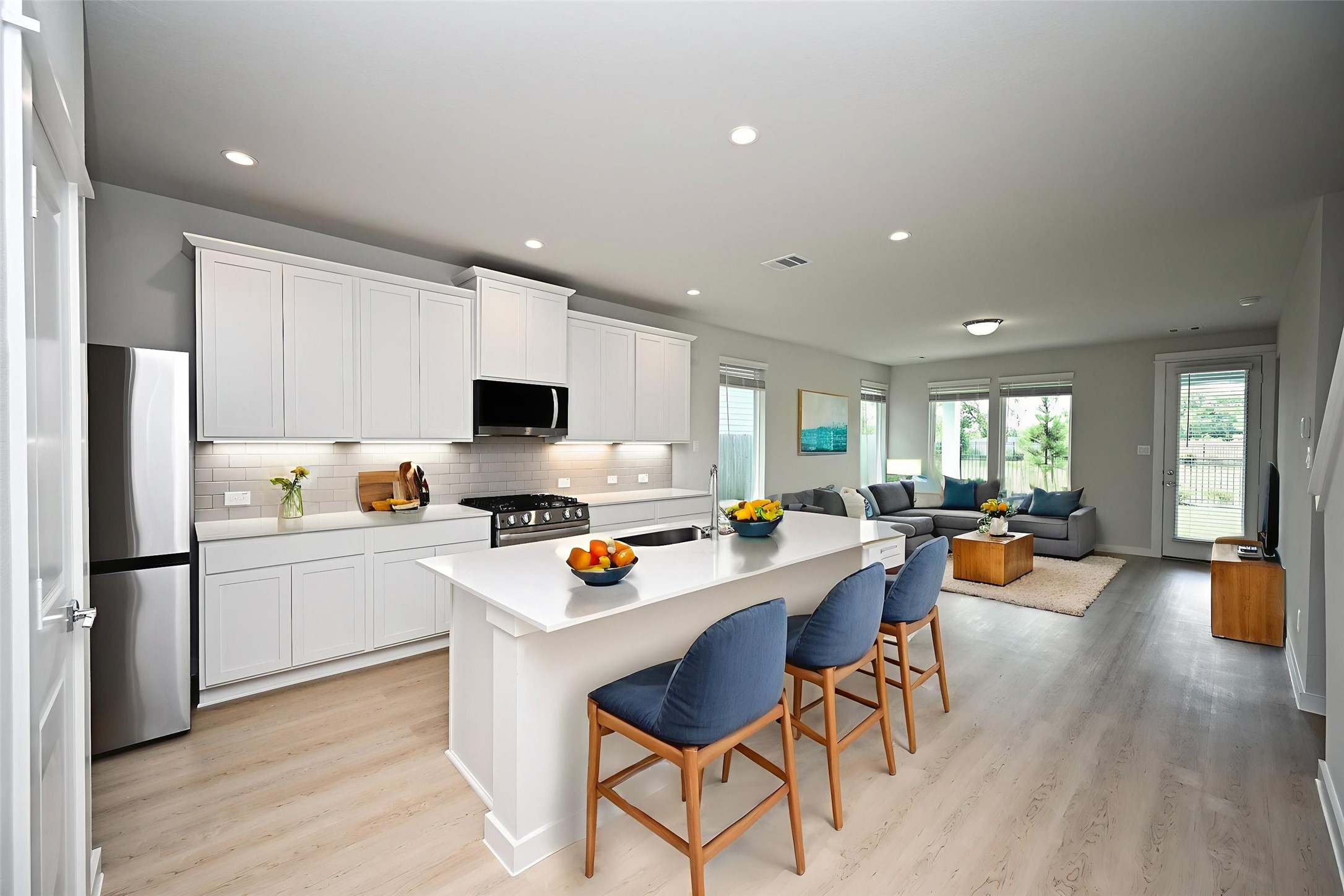 33019 School Hl Road Fulshear, TX 77441 - Photo 9 of 38 a kitchen with a sink a counter and chairs in it