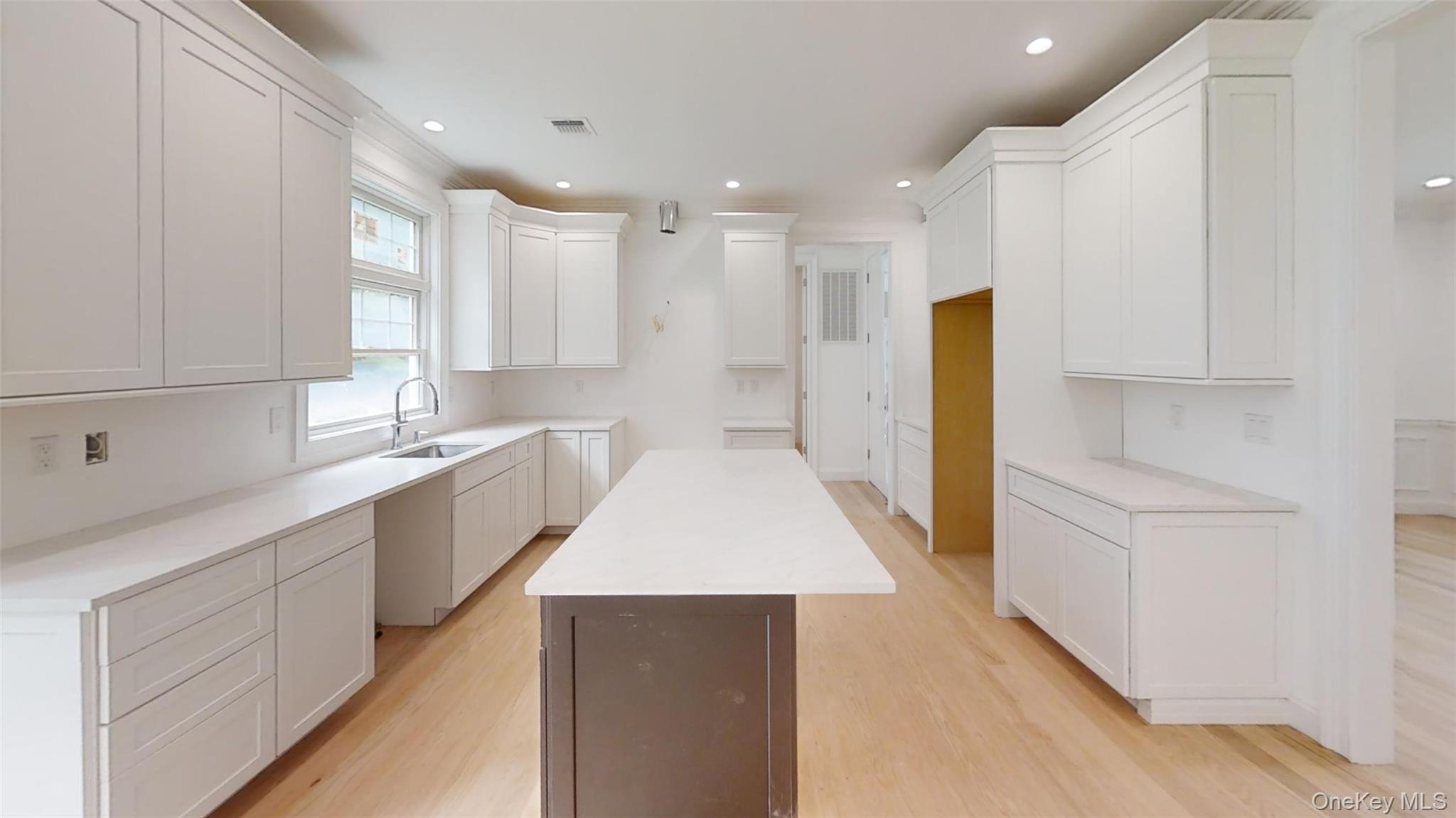 10 Winfield Drive Sound Beach, NY 11789 - Photo 4 of 11 a large white kitchen with kitchen island white cabinets and stainless steel appliances
