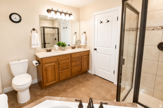 896 Cres Drive South Mapleton, UT 84664 - Photo 16 of 32 Dual vanity with wood-finish cabinetry, light-toned countertop, and bronze fixtures