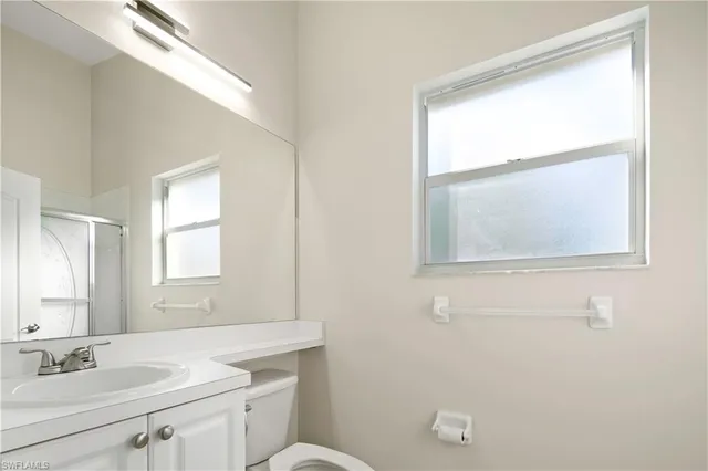 a bathroom with a sink a toilet and a window