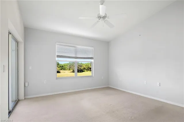 an empty room with windows and air conditioner vent