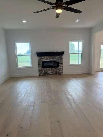 an empty room with windows and ceiling fan