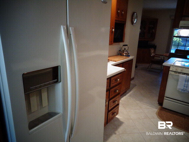 2804 Pine Ridge Drive Lillian, AL 36549 - Photo 14 of 39 Almond Whirlpool side by side refrigerator/freezer with ice/water dispenser.
