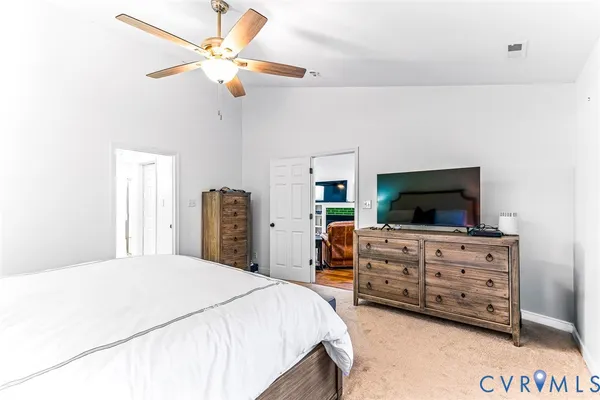 a bedroom with a bed a dresser and a chandelier