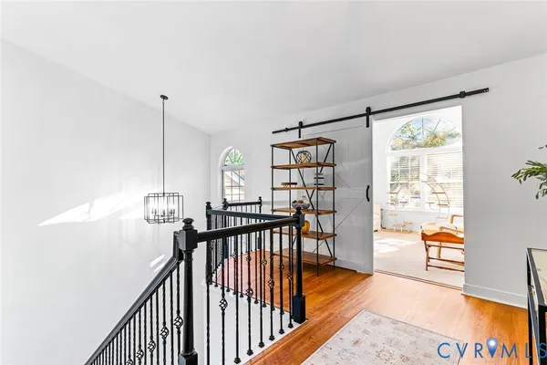 a view of hallway with wooden floor and windows