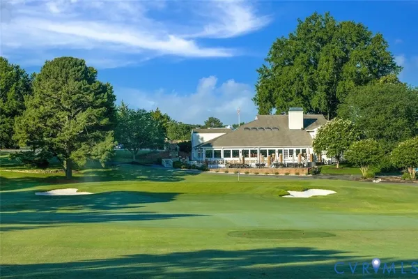 a view of a big house with a big yard and large trees
