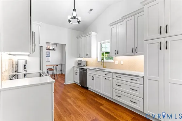 a kitchen with granite countertop a sink cabinets stainless steel appliances and a window