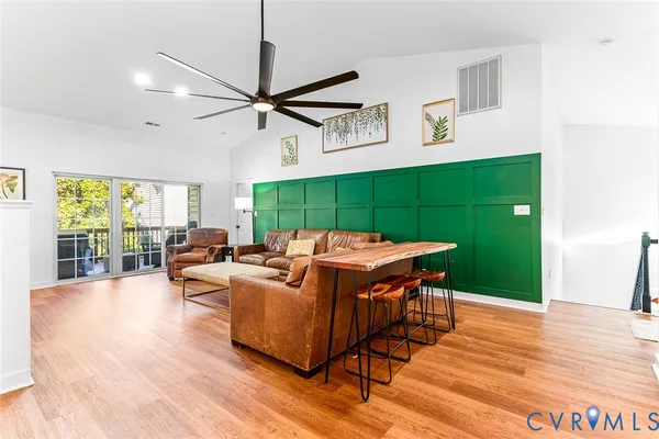 a living room with furniture a window and wooden floor