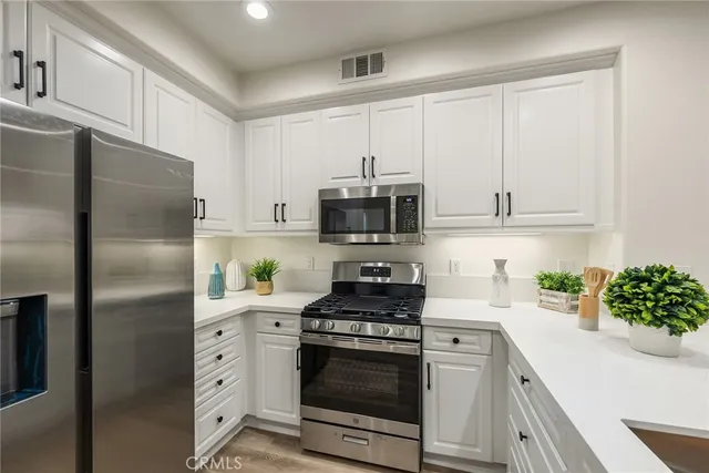 a kitchen with stainless steel appliances granite countertop a refrigerator sink and stove