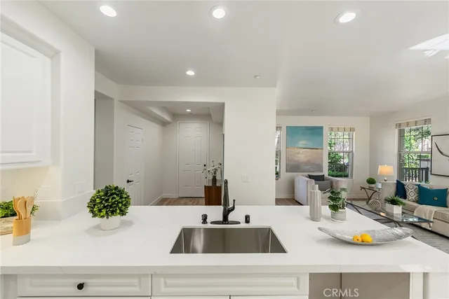 a kitchen with sink and view of living room