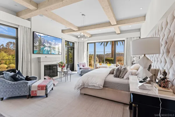 a bedroom with furniture a fireplace and a flat screen tv