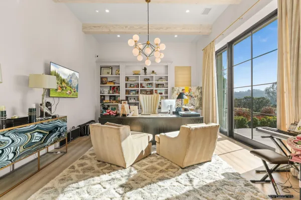 a living room with couch a dining table and a chandelier