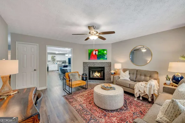 a living room with furniture a fireplace and a chandelier