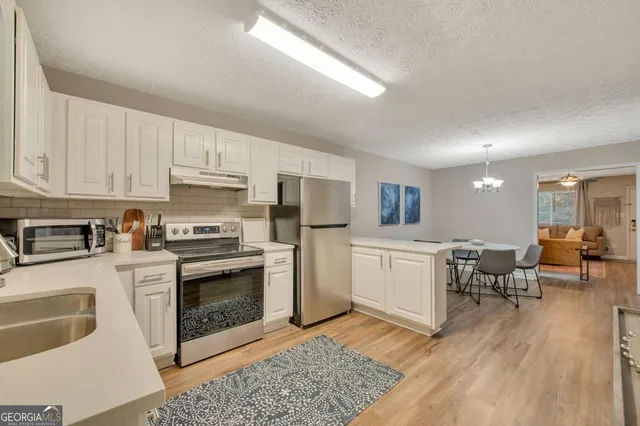 a kitchen with a white stove top oven and cabinets