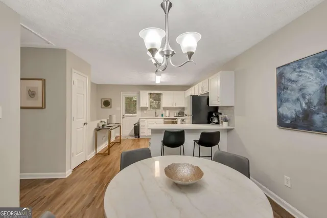 a kitchen with stainless steel appliances a dining table and chairs