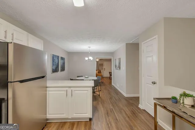 a kitchen with stainless steel appliances a refrigerator a sink a stove a dining table and chairs