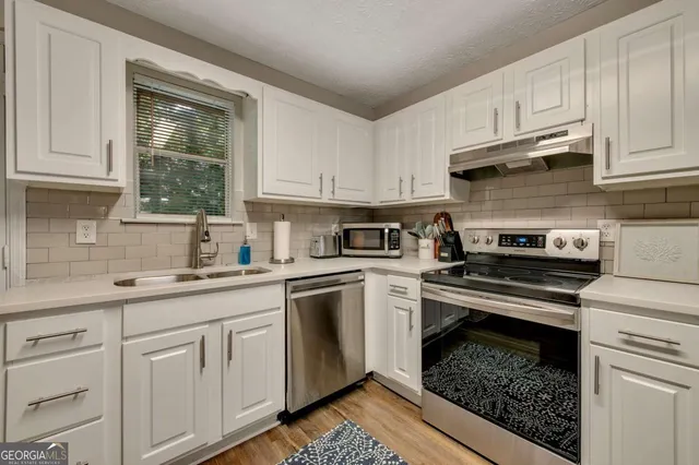a kitchen with cabinets appliances and a window
