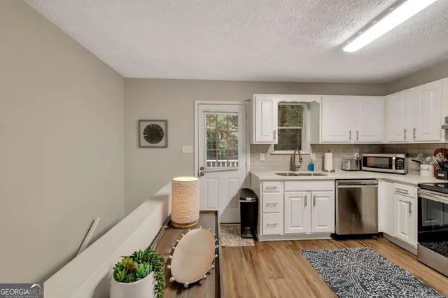 a kitchen with a sink dining table and chairs