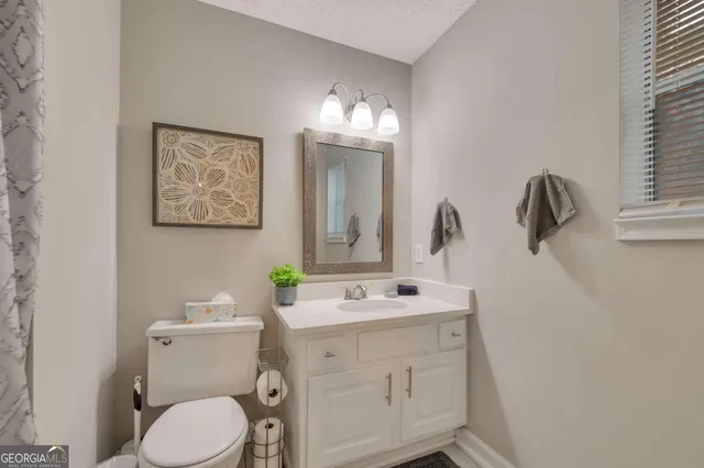 a bathroom with a toilet sink and mirror