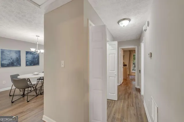 a view of a hallway with wooden floor and furniture