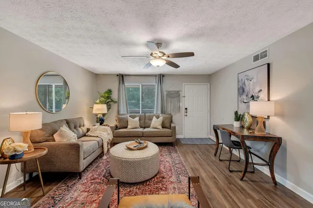 a living room with furniture a table and a large window