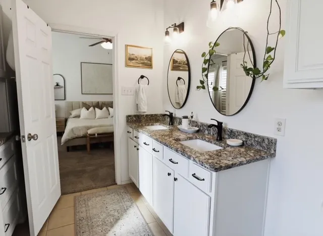 a bathroom with a granite countertop sink and a mirror