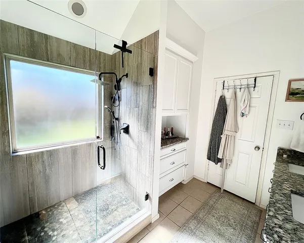 a en suite bathroom with a granite countertop sink and a mirror