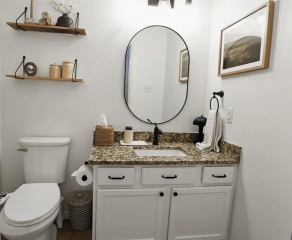 a bathroom with a toilet a sink and a mirror