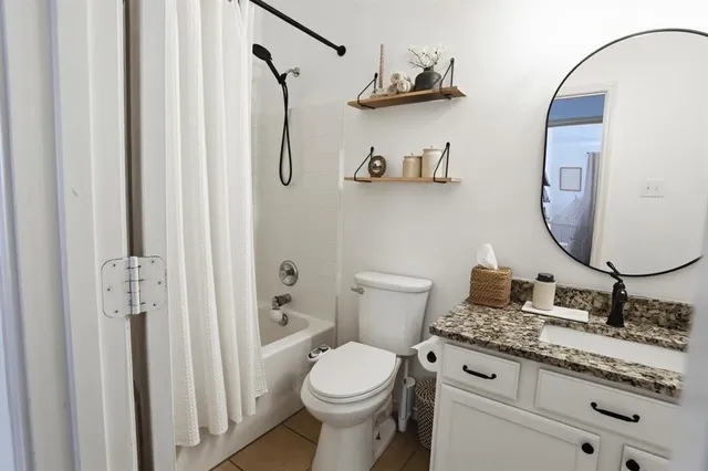 a bathroom with a granite countertop sink a toilet and a mirror