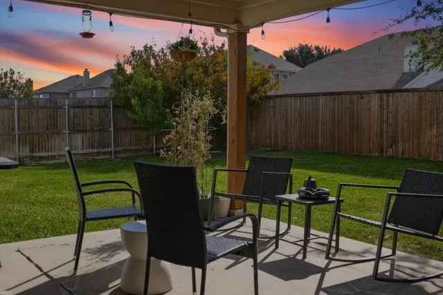 a view of a chairs and table in backyard