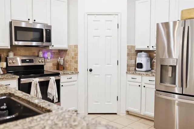 a kitchen with stainless steel appliances a refrigerator stove and microwave