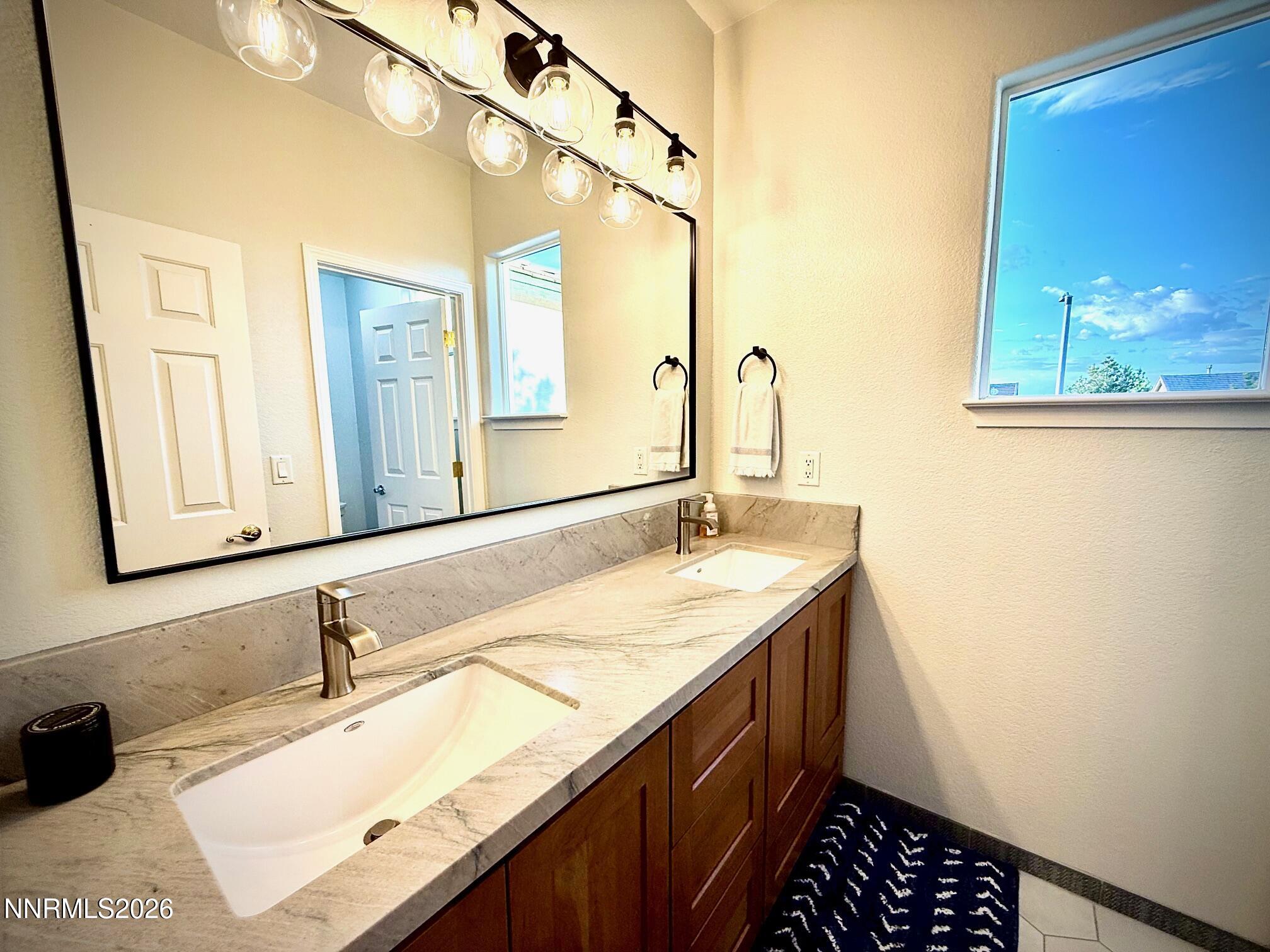 1771 Emerald Bay Drive Reno, NV 89521 - Photo 20 of 31 a bathroom with a granite countertop sink and a mirror