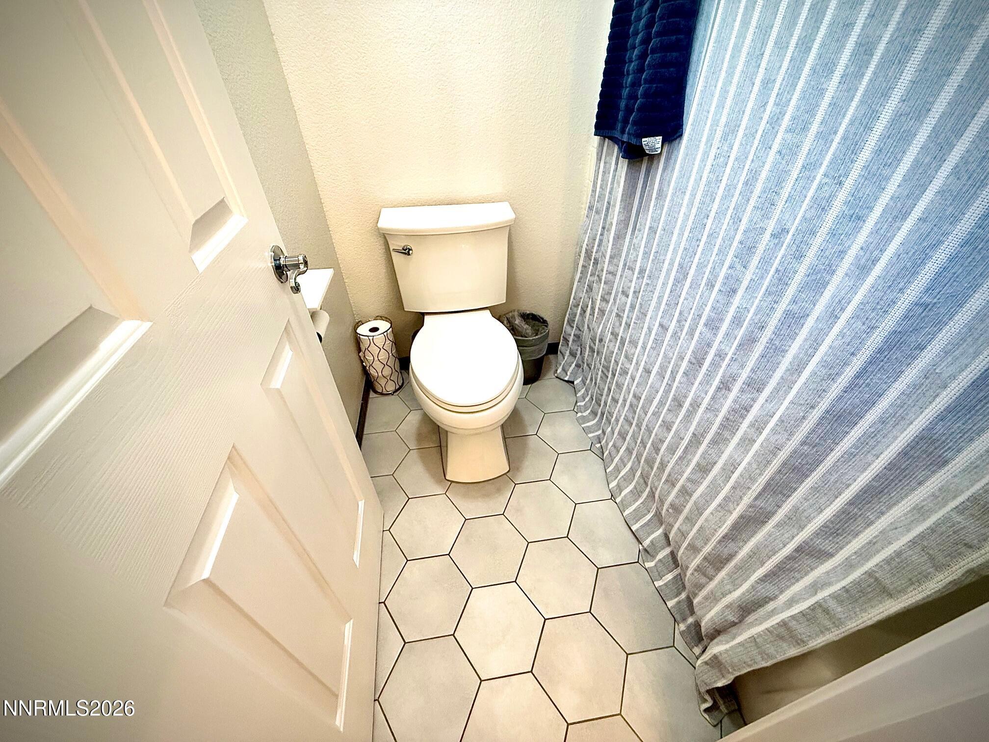 1771 Emerald Bay Drive Reno, NV 89521 - Photo 21 of 31 a white toilet sitting next to a shower curtain